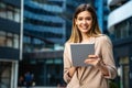 Portrait of a successful business woman using digital tablet in front of modern business building Royalty Free Stock Photo