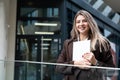 Portrait of a successful business woman using digital tablet in front of modern business office building. Professional female, Royalty Free Stock Photo