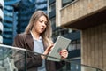 Portrait of a successful business woman using digital tablet in front of modern business office building. Professional female, Royalty Free Stock Photo