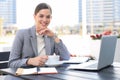 Portrait of successful business woman using laptop and smiling while sitting in cafe, outdoor Royalty Free Stock Photo