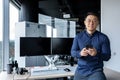 Portrait of successful businessman, man holding smartphone, asian man working inside modern office building using dual Royalty Free Stock Photo