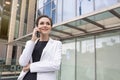 A portrait of a successful businesswoman speaking over a cell phone in the street. A manager, company employee