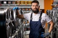 portrait of successful caucasian car mechanic in a workshop on a stack of tires at his workplace