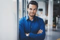 Portrait of successful confident hispanic businessman smiling and standing close from the window in modern office