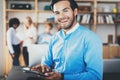 Portrait of successful confident hispanic businessman using tablet in the hands and smiling at camera in modern office Royalty Free Stock Photo