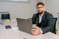 Portrait of successful confident male manager employee sitting at table with computer, posing in modern office Royalty Free Stock Photo