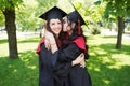 Portrait of successful graduate female students wearing cap outdoors near university