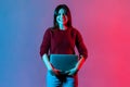 Portrait of successful happy office worker, pretty girl in casual pullover standing, holding closed laptop or folder Royalty Free Stock Photo