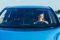 Portrait of a successful and happy woman driving a car, photo from the front through the glass Royalty Free Stock Photo