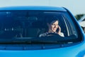 Portrait of a successful and happy woman driving a car, photo from the front through the glass Royalty Free Stock Photo