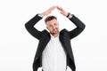 Portrait of successful man wearing black jacket winking and gesturing while smiling on camera, isolated over white background Royalty Free Stock Photo