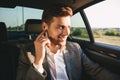 Portrait of successful man wearing suit and earpod having mobile