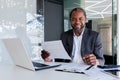 Portrait of successful mature experienced financier, business man behind paper work smiling and looking at camera Royalty Free Stock Photo