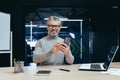 Portrait of successful mature investor inside office with work, gray-haired businessman smiling and looking at camera