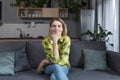 Portrait of successful middle-aged woman, housewife sitting on sofa in kitchen and smiling looking at camera Royalty Free Stock Photo