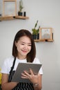 A successful owner woman and using digital tablet while sitting in her coffee shop. Royalty Free Stock Photo