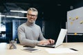 Portrait of successful senior businessman, gray haired man in glasses smiling and looking at camera, mature investor