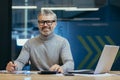 Portrait of successful senior businessman, gray haired man in glasses smiling and looking at camera, mature investor