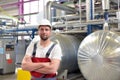 Portrait of successful smiling workers/ engineers on site in an industrial factory with helmet