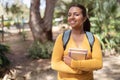 Portrait of successful student girl posing holding books, smiling at camera standing in college campus or park outside Royalty Free Stock Photo