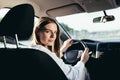 Portrait of a successful woman driving a car, smiling rejoicing and looking at the camera Royalty Free Stock Photo