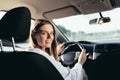 Portrait of a successful woman driving a car, smiling rejoicing and looking at the camera Royalty Free Stock Photo