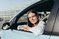 Portrait of a successful woman driving a car, smiling rejoicing and looking at the camera Royalty Free Stock Photo