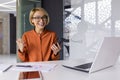 Portrait of successful woman winner, businesswoman smiling and looking at camera, worker holding phone in hands received Royalty Free Stock Photo