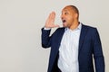 Portrait of a successful young African American businessman guy yelling and shouting loudly to the side with hand over Royalty Free Stock Photo