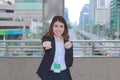 Portrait of successful young Asian business woman looking confident and smiling at urban city background. Royalty Free Stock Photo