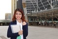 Portrait of successful young Asian business woman standing and looking confident against urban background. Royalty Free Stock Photo