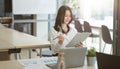 Portrait of successful young Asian businesswoman working with financial report at meeting room. Royalty Free Stock Photo