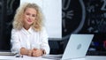 Portrait of successful young female teamleader having good time indoor sitting at table