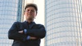 Portrait of a successful young handsome engineer, architect, builder, businessman, wearing a white helmet, in a suit, holding a pr