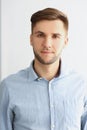 Successful young man in stylish grey shirt, presentable guy posing on white