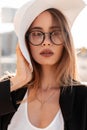 Portrait sunny beautiful young woman in fashionable elegant clothes in stylish glasses outdoors at sunset. Modern attractive girl Royalty Free Stock Photo