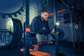 Portrait of super fit muscular young man working out in gym with barbell Royalty Free Stock Photo