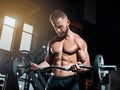 Portrait of super fit muscular young man working out in gym with barbell Royalty Free Stock Photo