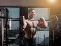 Portrait of super fit muscular young man working out in gym with barbell Royalty Free Stock Photo