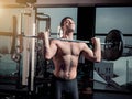 Portrait of super fit muscular young man working out in gym with barbell Royalty Free Stock Photo