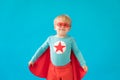 Portrait of superhero child against blue background