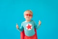 Portrait of superhero child against blue background