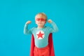 Portrait of superhero child against blue background