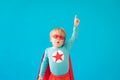 Portrait of superhero child against blue background