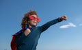 Portrait of superhero kid against blue sky background. Copy space.