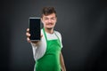Portrait supermarket employer showing smartphone and smiling