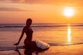 Portrait of surfer girl with beautiful body on the beach with surfboard at colourful sunset time Royalty Free Stock Photo