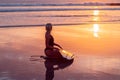 Portrait of surfer girl with beautiful body on the beach with surfboard at colourful sunset time Royalty Free Stock Photo