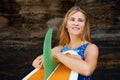 Portrait of surfer girl with surfboard on sea cliff background Royalty Free Stock Photo