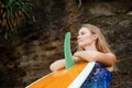 Portrait of surfer girl with surfboard on sea cliff background Royalty Free Stock Photo